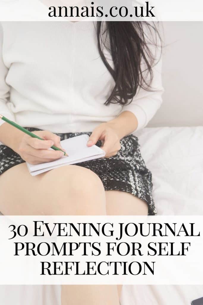 woman sits in pyjamas writing evening journal prompts in a notebook