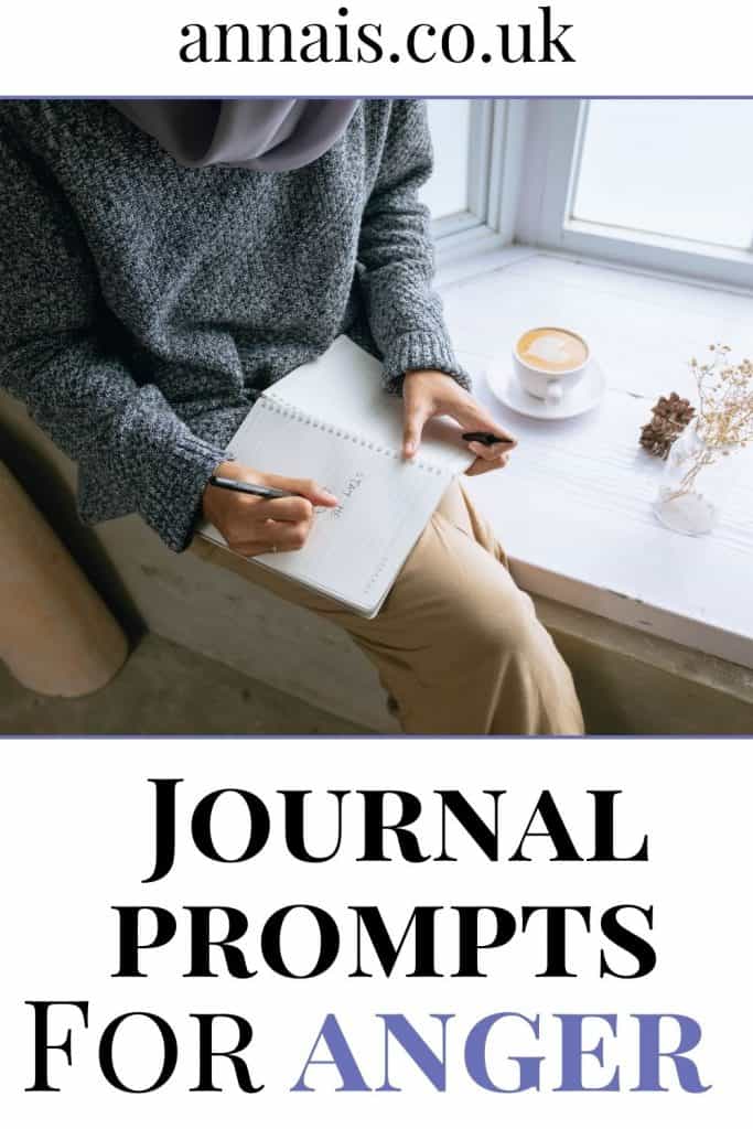 woman sits at a table writing journal prompts for anger